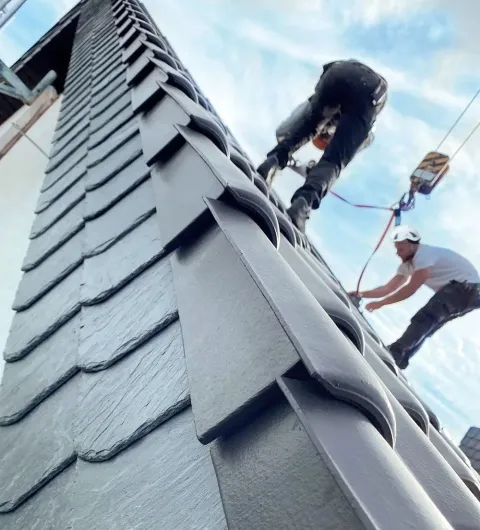 Dachdecker bei der Arbeit auf einem Hausdach