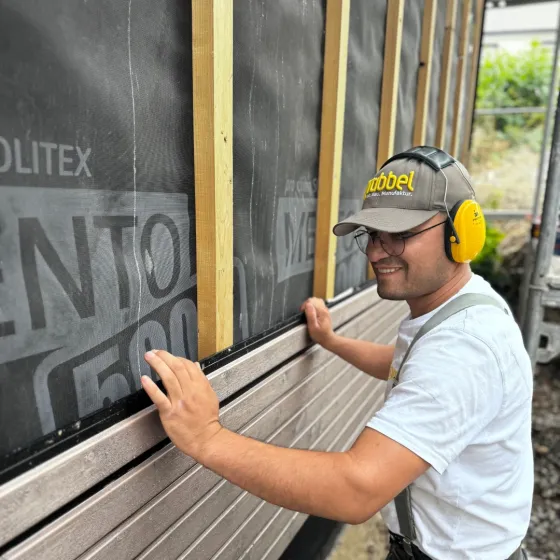 Handwerker montiert eine Holzfassade