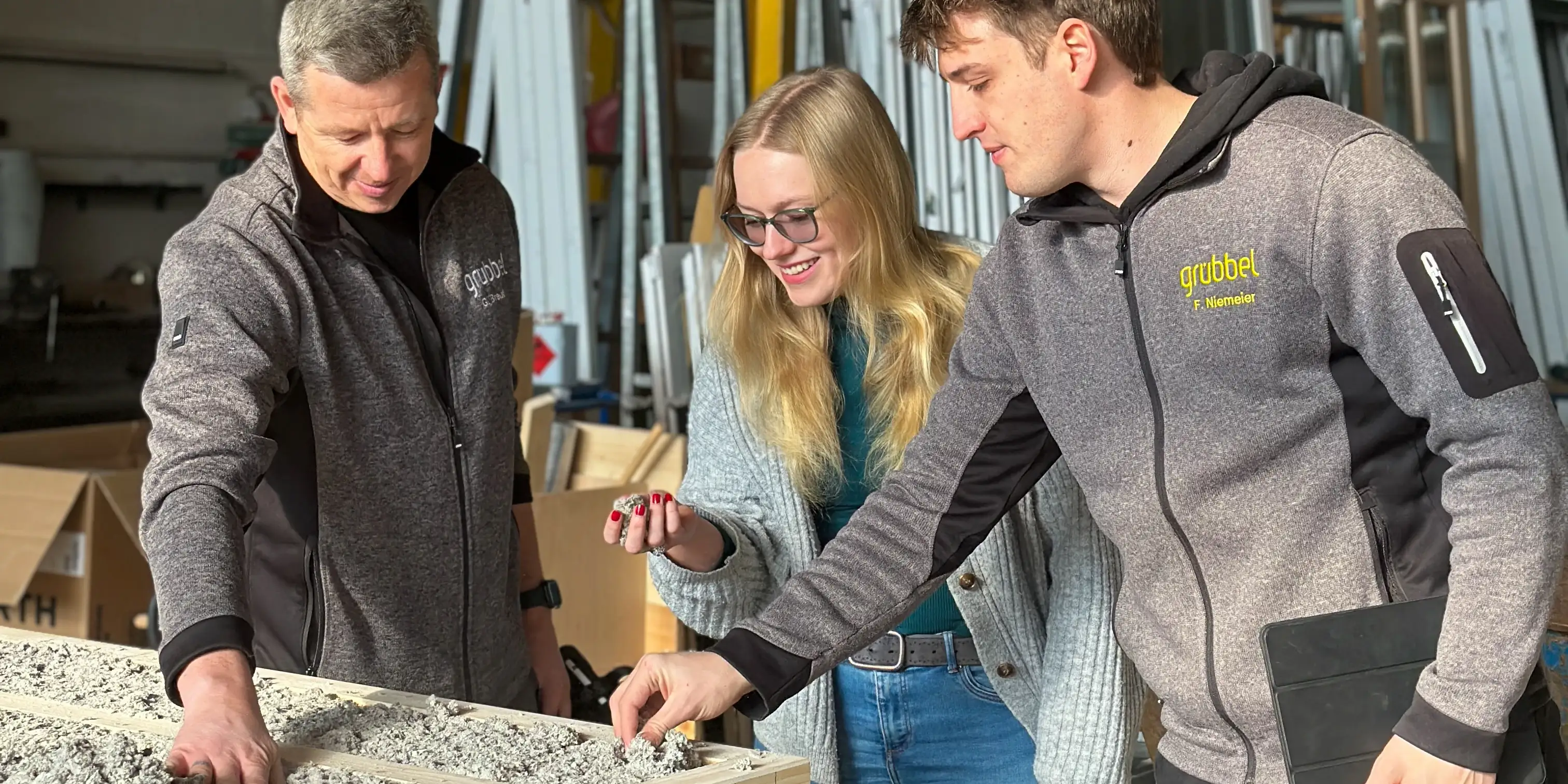 Drei Personen an einer gedämmten Holzrahmenwand