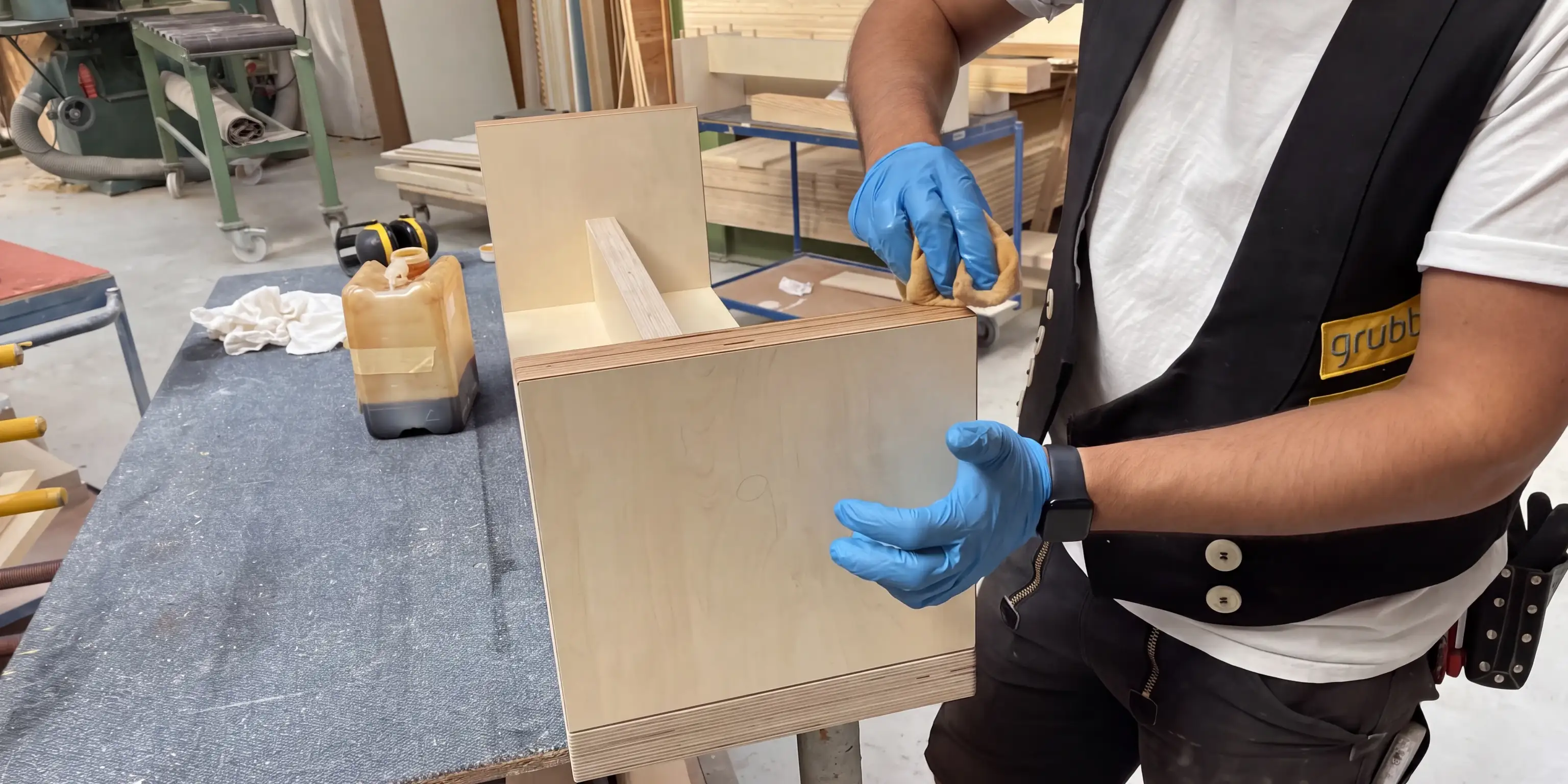 Tischler bearbeitet ein Holzmöbel in der Werkstatt