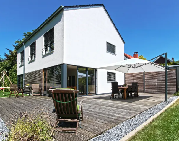 Weißes Haus mit Holzterrasse