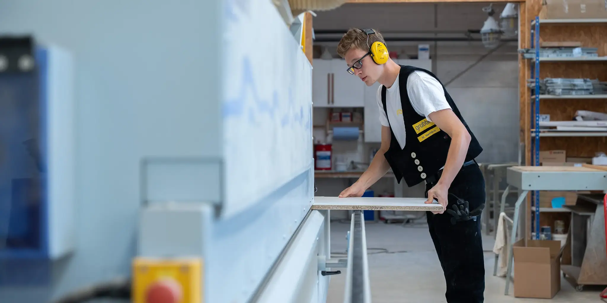 Mitarbeiter bearbeitet Holz in der Werkstatt