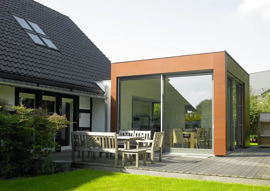 Anbau: Anbau mit orangefarbenem Rahmen und Holzterrasse