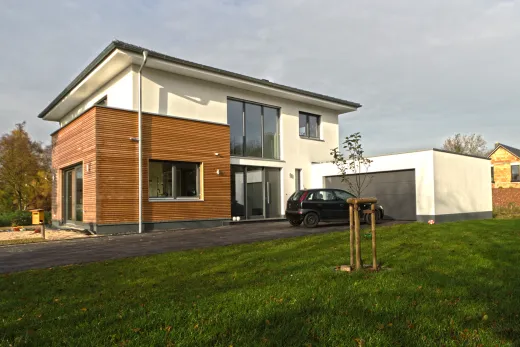 Garagenanbau mit Aufstockung in Bad Oeynhausen: Wohnhaus mit holzverkleidetem Anbau und Garage