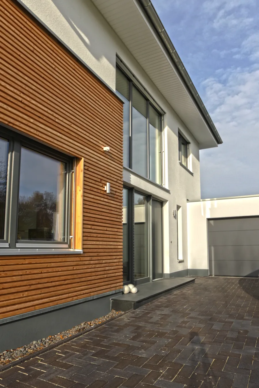 Garagenanbau mit Aufstockung in Bad Oeynhausen: Holzfassade des Anbaus mit großer Verglasung