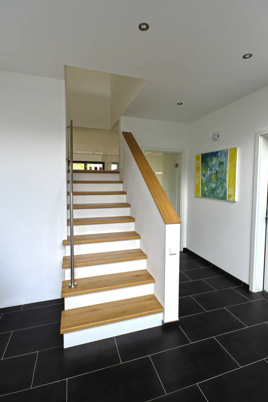 Garagenanbau mit Aufstockung in Bad Oeynhausen: Treppe mit Holzstufen im Eingangsbereich