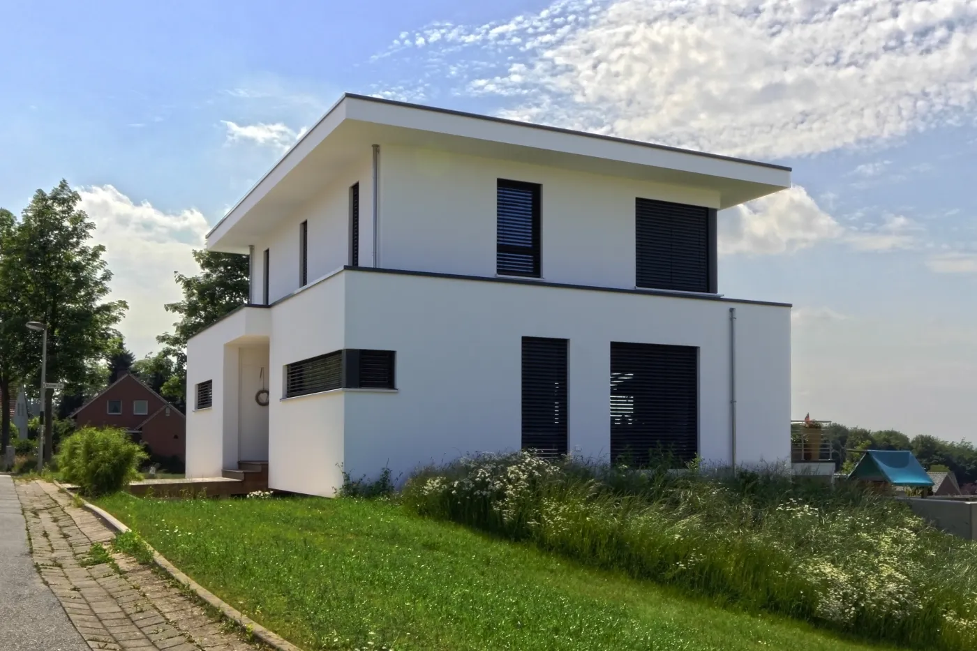 Wohnhaus in Bad Oeynhausen: Weißes Wohnhaus mit Flachdach am Hang