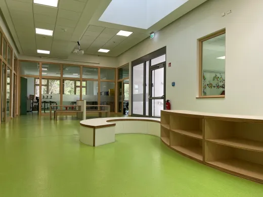 Kita in Bad Oeynhausen: Flur einer Kita mit grünem Boden und Holzmöbeln