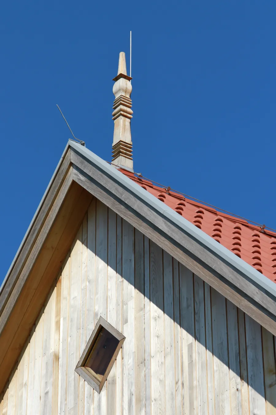 Bauen im Bestand: Giebel mit Holzverschalung und Firstschmuck
