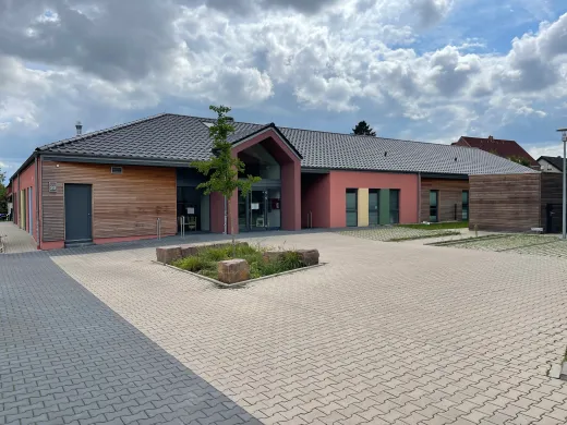 Kita in Holzrahmenbauweise in Herford: Kita mit Holz- und Putzfassade und Vorplatz