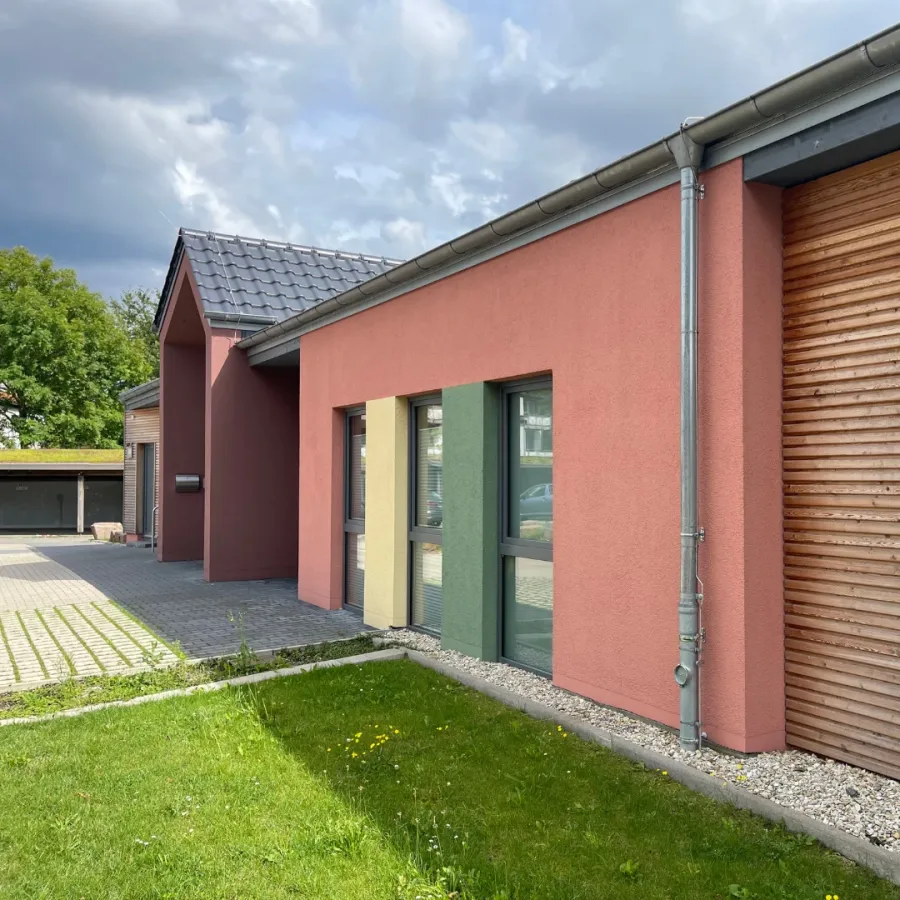 Kita in Holzrahmenbauweise in Herford: Kita-Fassade in Rosa mit Holzverkleidung