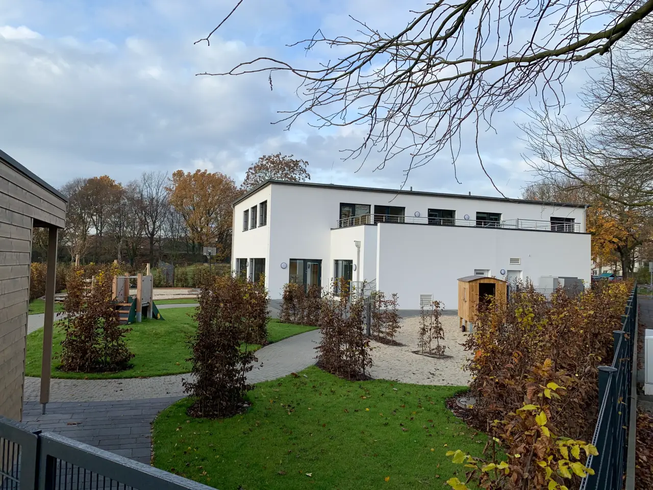 Kita in Hannover: Weißer Kita-Neubau mit Außengelände