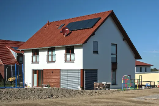 Einfamilienhaus in Bad Oeynhausen: Satteldachhaus mit roten Ziegeln, Solarkollektoren und Holzverkleidung im Erdgeschoss