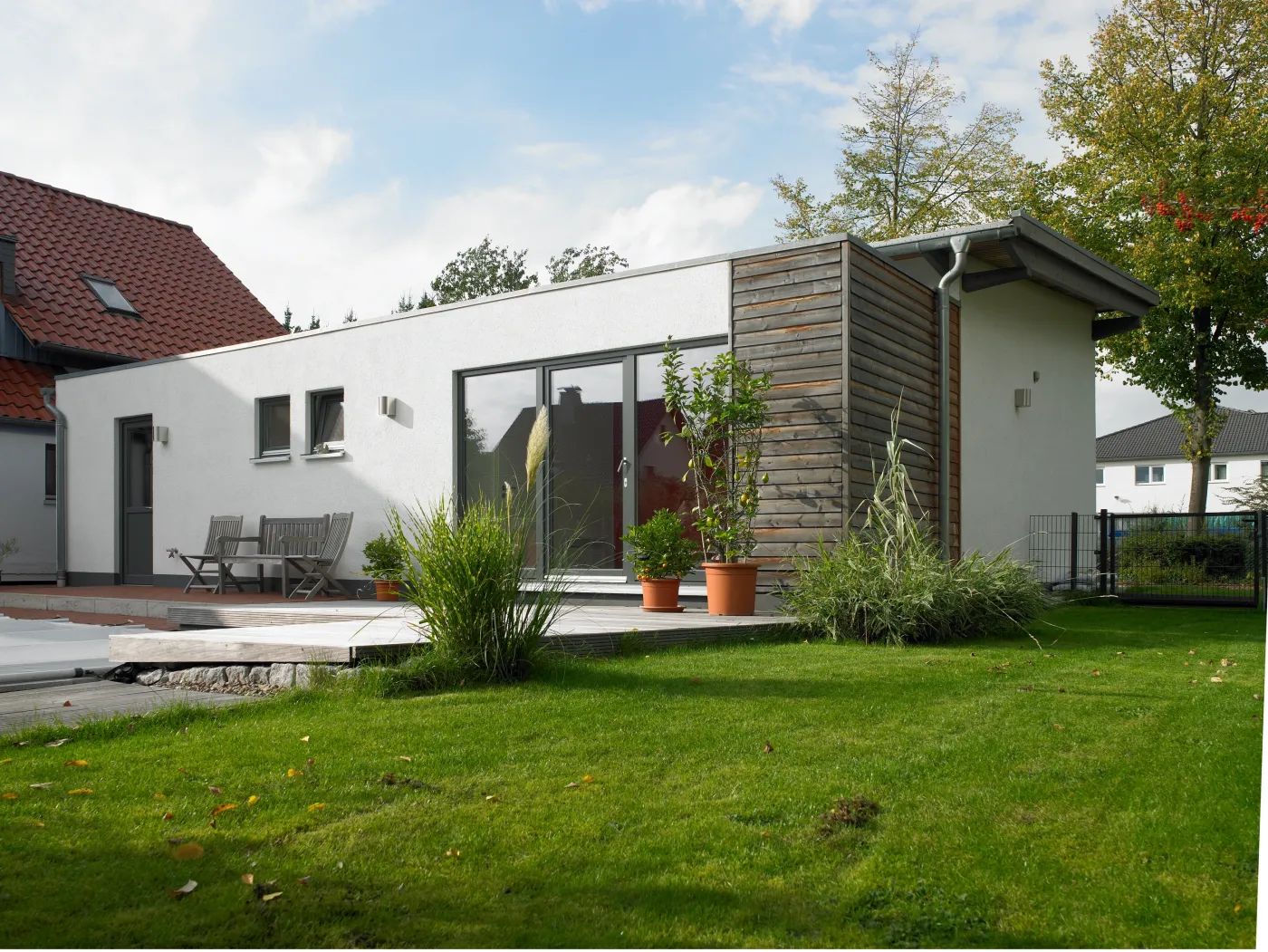 Einfamilienhaus in Bad Oeynhausen: Flachdachanbau mit Holzfassade und Terrasse
