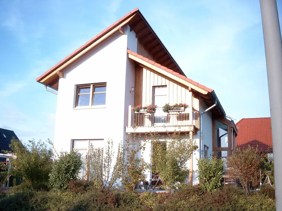 Einfamilienhaus in Bad Oeynhausen: Wohnhaus mit Holzbalkon im Giebel