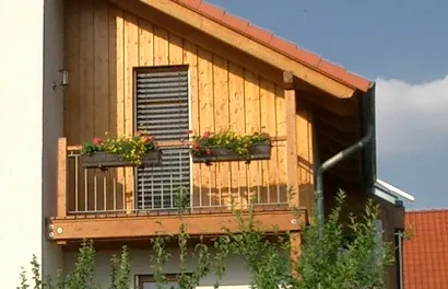 Einfamilienhaus in Bad Oeynhausen: Holzbalkon mit Blumenkästen im Giebel