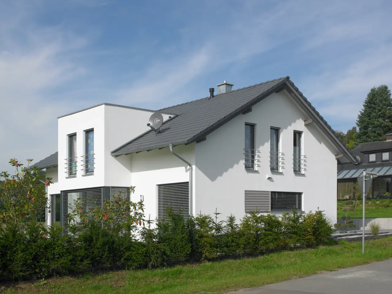 Einfamilienhaus in Bad Oeynhausen: Weißes Wohnhaus mit Satteldach und Hecke