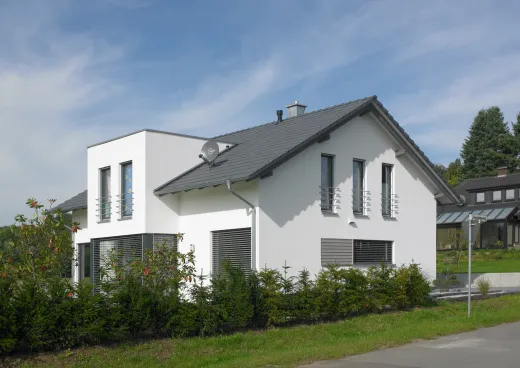 Einfamilienhaus in Bad Oeynhausen: Weißes Wohnhaus mit Satteldach und Hecke