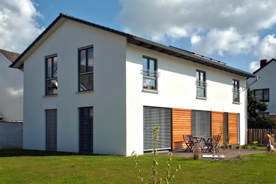 Einfamilienhaus in Bad Oeynhausen: Weißes Satteldachhaus mit Holzelementen und Terrasse