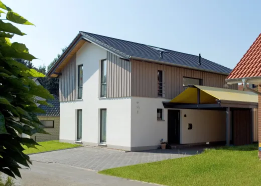 Einfamilienhaus in Bad Oeynhausen: Wohnhaus mit Holzverschalung im Giebel und Carport