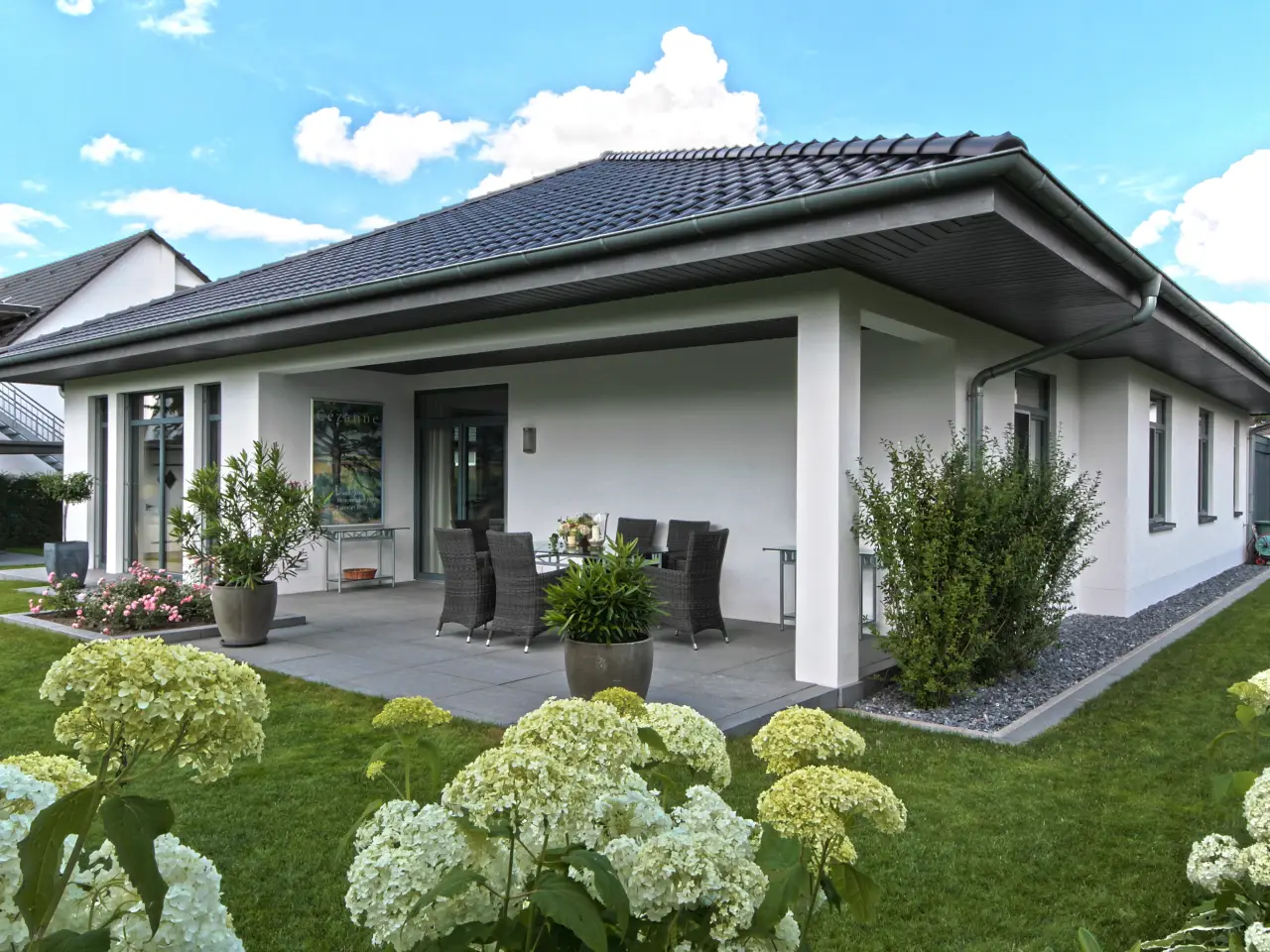 Einfamilienhaus in Bad Oeynhausen: Bungalow mit Walmdach und überdachter Terrasse im Garten