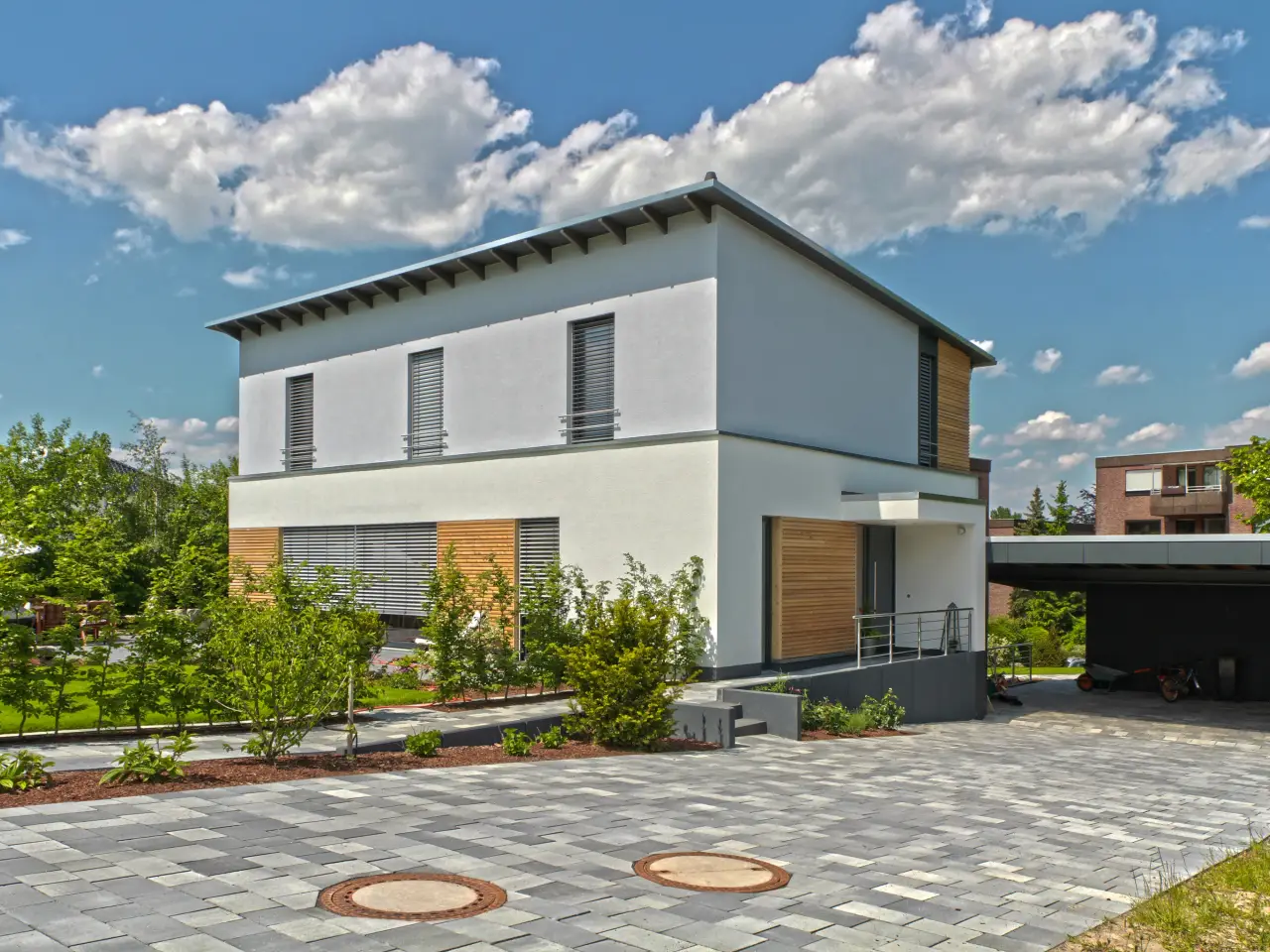 Einfamilienhaus in Bad Oeynhausen: Wohnhaus mit flachem Walmdach, Holzelementen und Carport