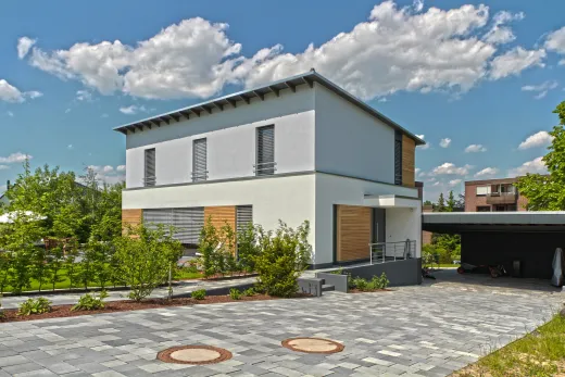 Einfamilienhaus in Bad Oeynhausen: Wohnhaus mit flachem Walmdach, Holzelementen und Carport