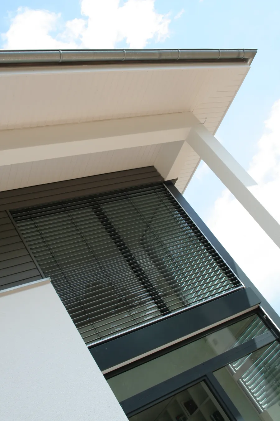 Einfamilienhaus in Bad Oeynhausen: Dachüberstand und Fenster mit Raffstore, Detail