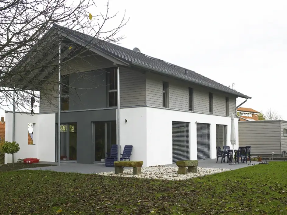 Einfamilienhaus in Bad Oeynhausen: Wohnhaus mit grauer Holzverschalung im Obergeschoss