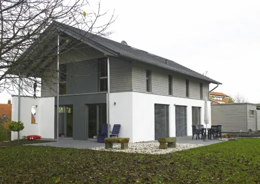 Einfamilienhaus in Bad Oeynhausen: Wohnhaus mit grauer Holzverschalung im Obergeschoss