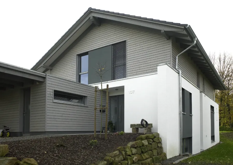 Einfamilienhaus in Bad Oeynhausen: Wohnhaus mit grauer Holzfassade und Anbau