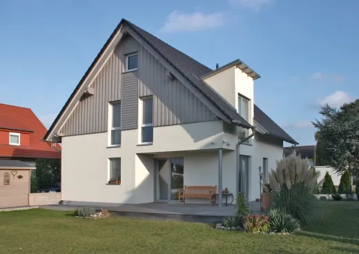 Einfamilienhaus in Bad Salzuflen: Wohnhaus mit Holzverschalung im Giebel und Terrasse