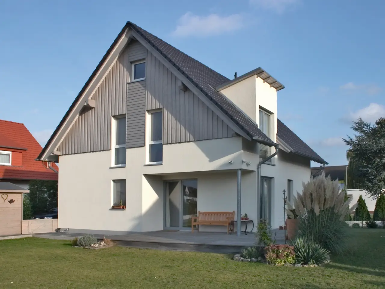 Einfamilienhaus in Bad Salzuflen: Wohnhaus mit Holzverschalung im Giebel und Terrasse