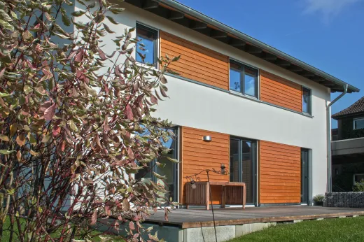 Einfamilienhaus in Bielefeld: Wohnhaus mit Holzverkleidung und Holzterrasse