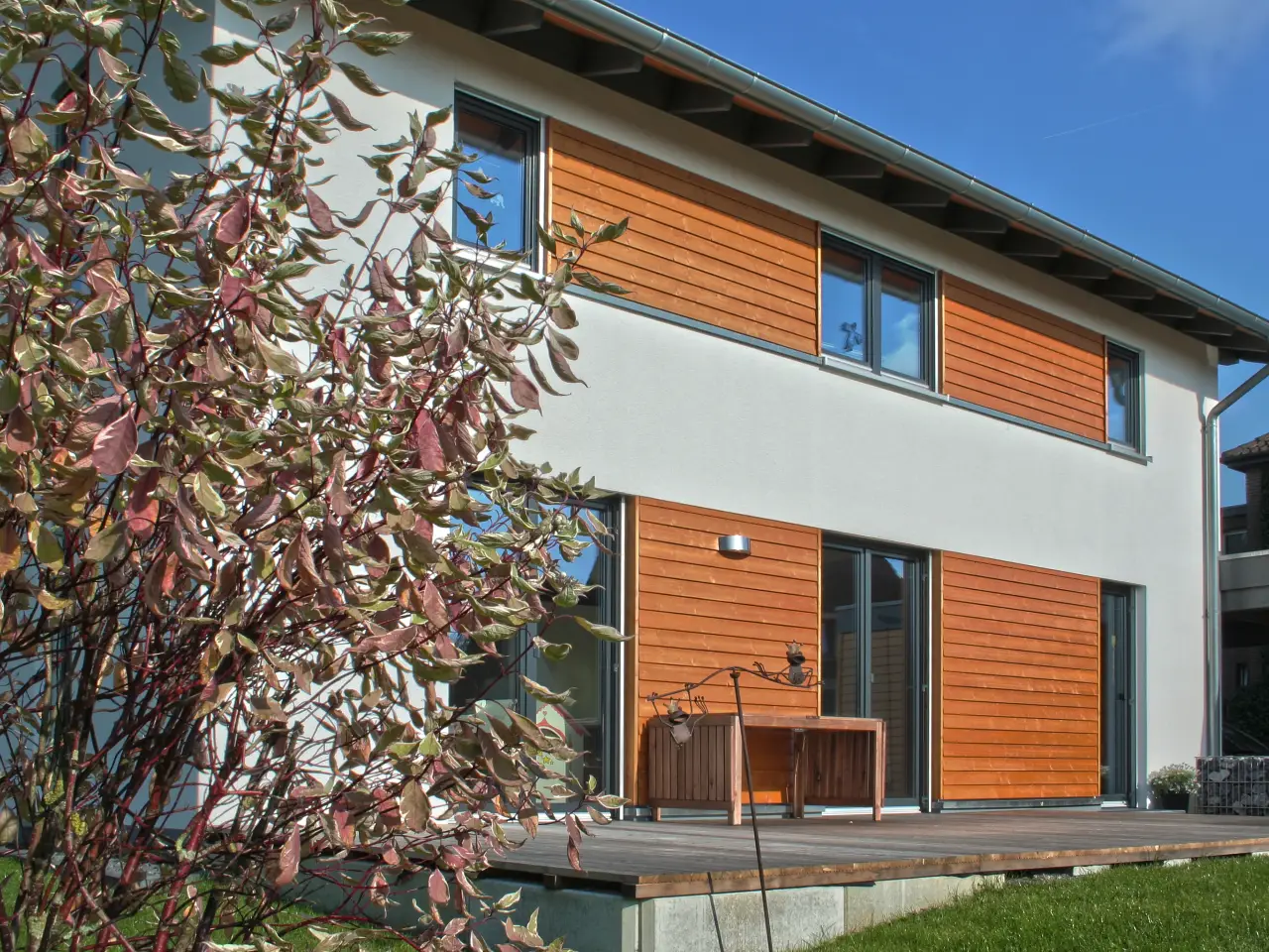 Einfamilienhaus in Bielefeld: Wohnhaus mit Holzverkleidung und Holzterrasse