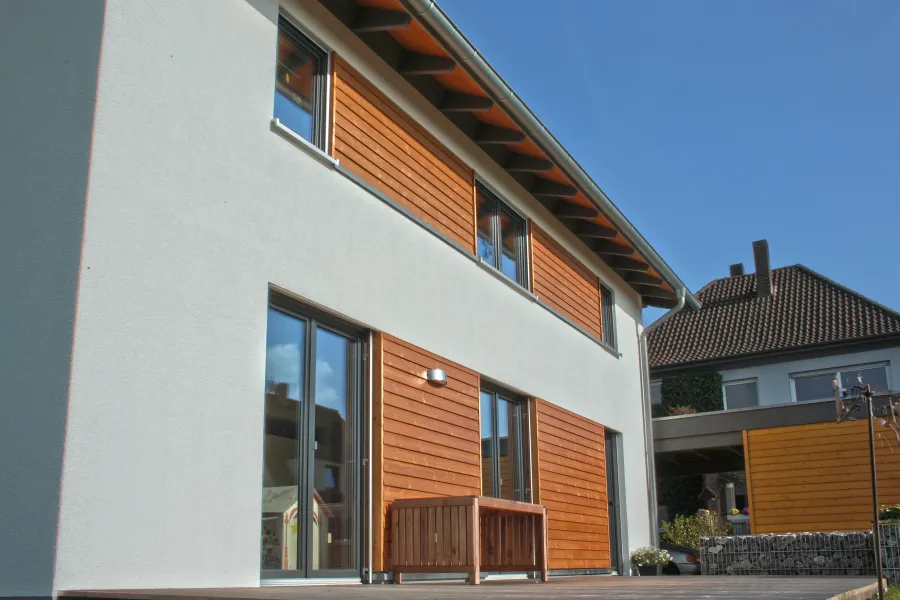 Einfamilienhaus in Bielefeld: Wohnhaus mit Holzverkleidung an Fassade und Terrasse
