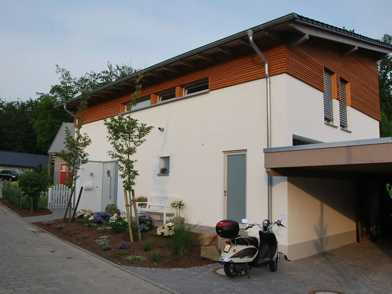 Einfamilienhaus in Herford: Wohnhaus mit Pultdach, Holzverkleidung und Carport