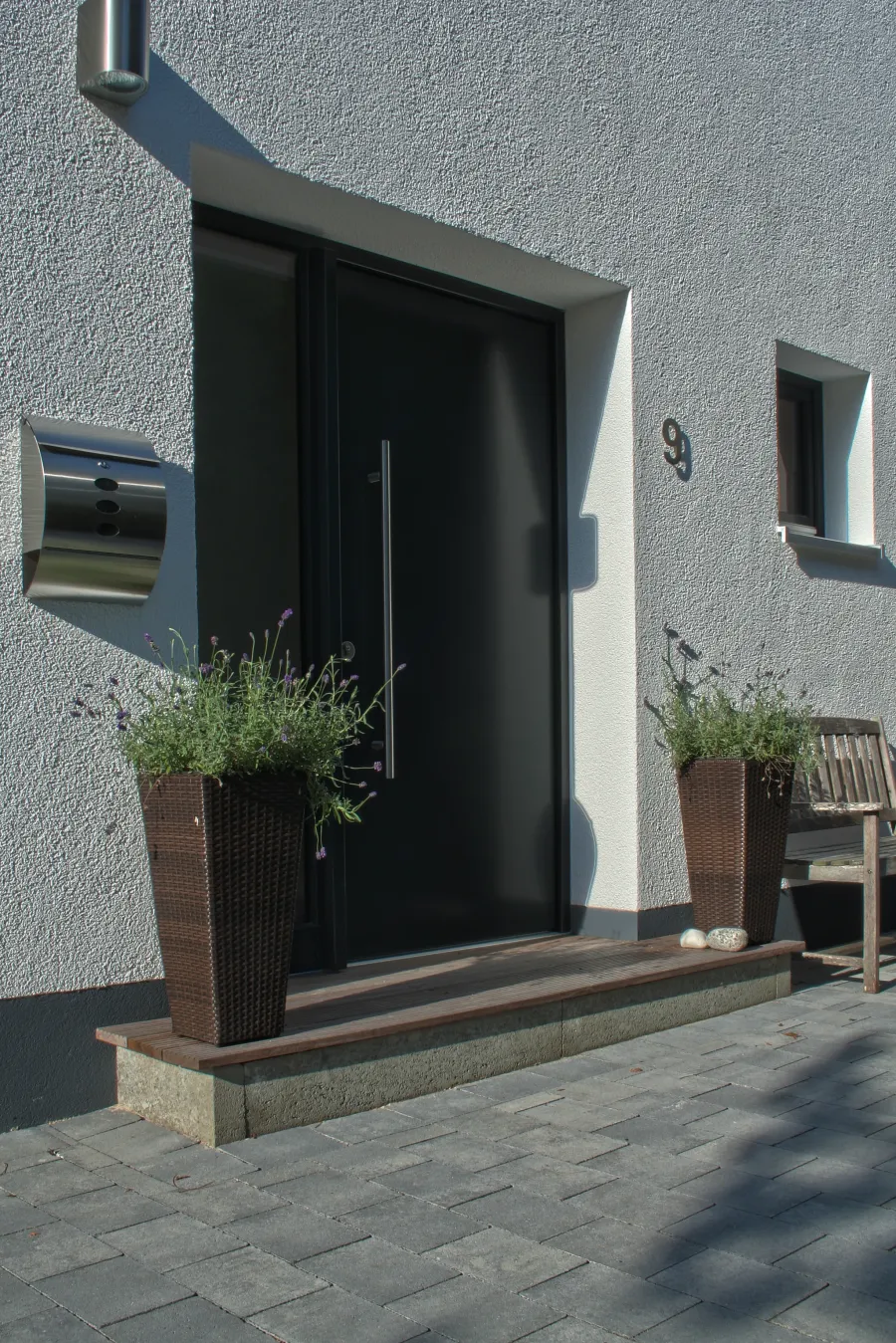 Einfamilienhaus in Hiddenhausen: Hauseingang mit dunkler Haustür und Pflanzkübeln