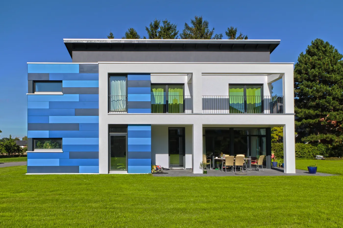 Einfamilienhaus in Hille: Moderne Hausfront mit blauen Fassadenplatten und Balkon