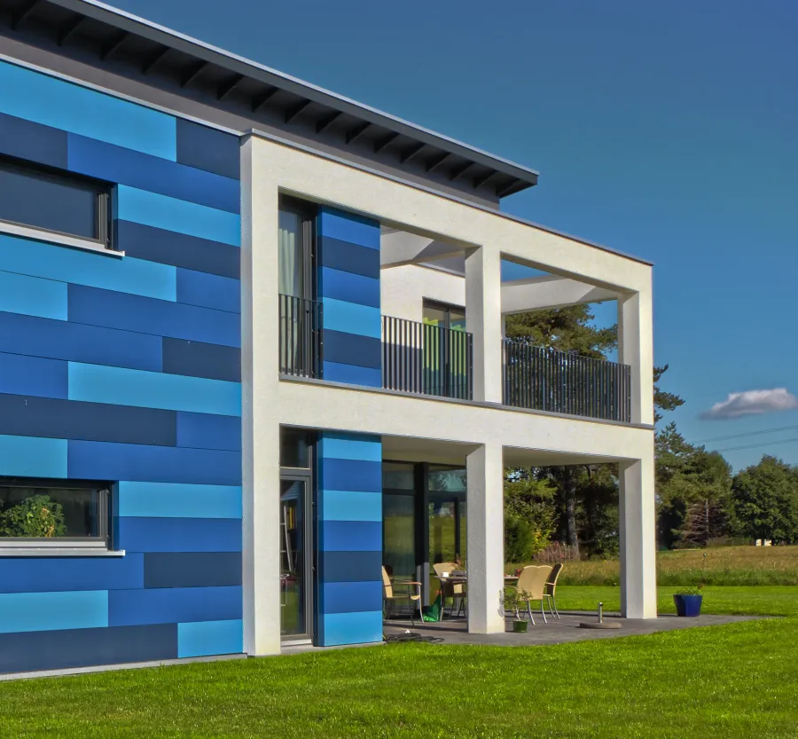 Einfamilienhaus in Hille: Blaue Fassadenplatten und Balkon, Seitenansicht