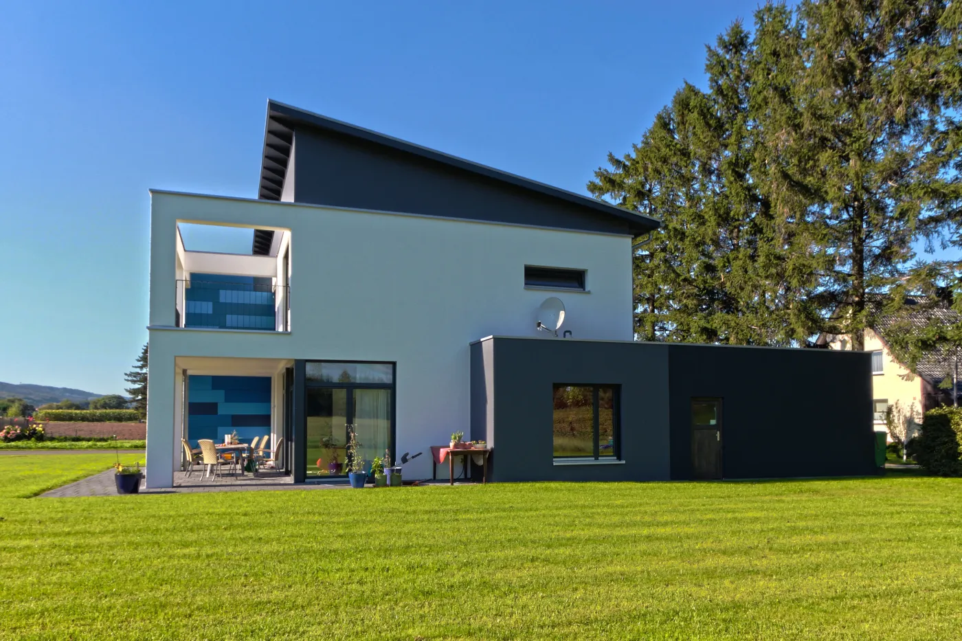 Einfamilienhaus in Hille: Wohnhaus mit Pultdach und blauen Fassadenelementen