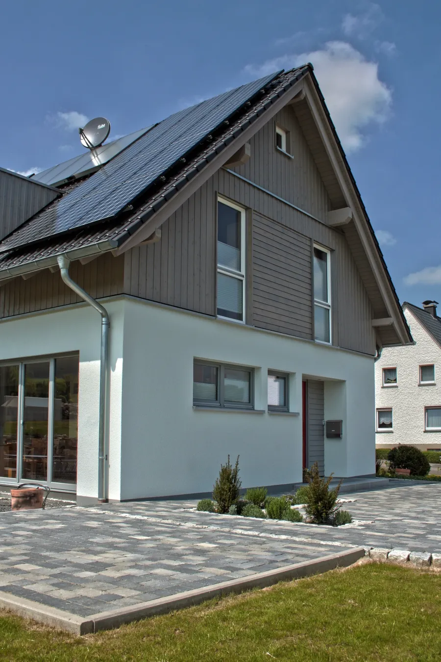 Einfamilienhaus in Holzhausen: Satteldachhaus mit Photovoltaik und Holzverschalung