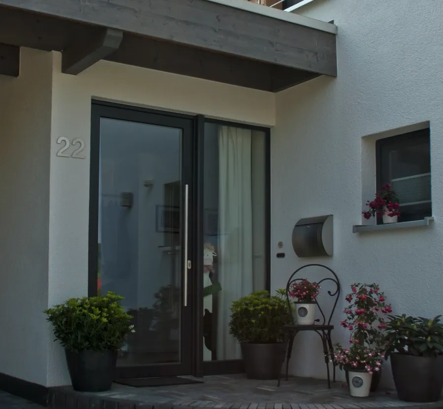 Einfamilienhaus in Holzhausen: Hauseingang mit Vordach und Blumen