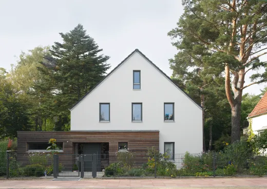 Einfamilienhaus in Kleinmachnow: Weißes Satteldachhaus mit holzverkleidetem Anbau