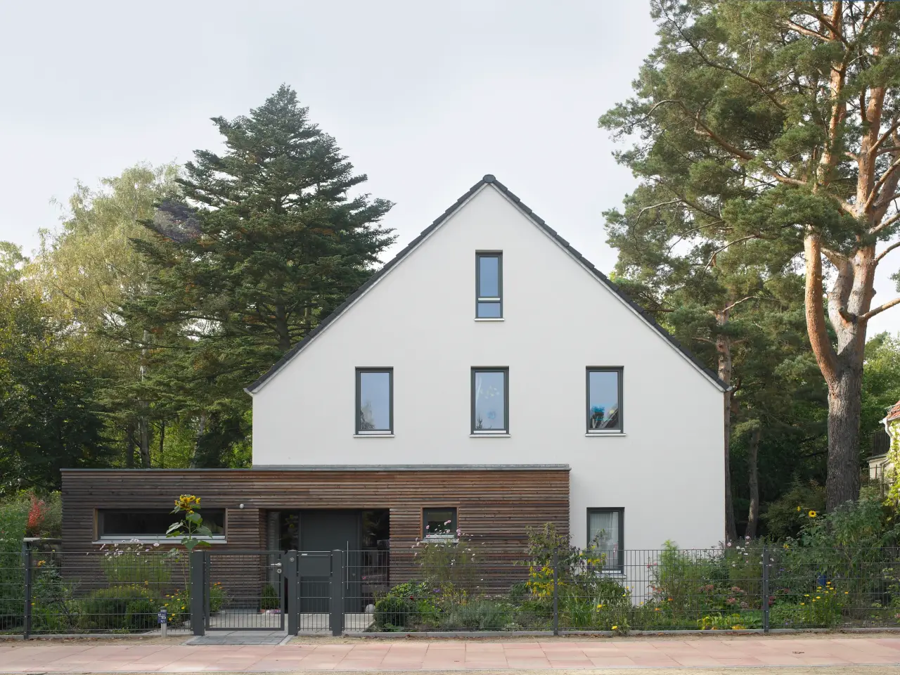 Einfamilienhaus in Kleinmachnow: Weißes Satteldachhaus mit holzverkleidetem Anbau