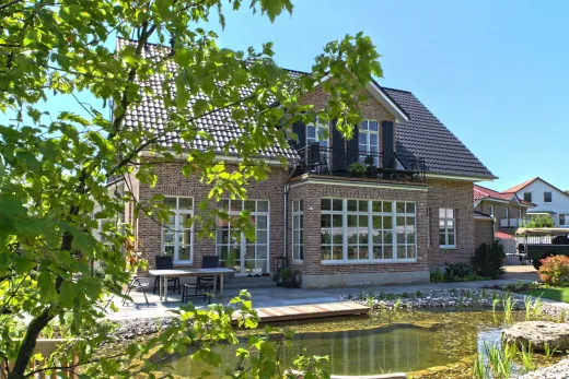 Landhausvilla in Minden: Landhausvilla mit Klinkerfassade und Gartenteich