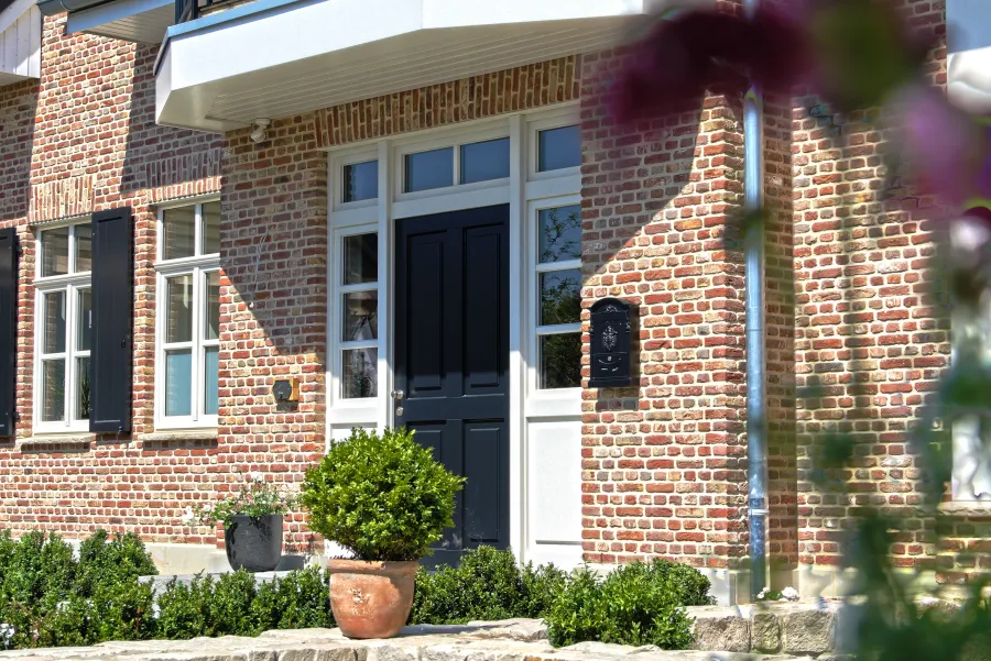 Landhausvilla in Minden: Eingang mit Klinker, Sprossenfenstern und Fensterläden