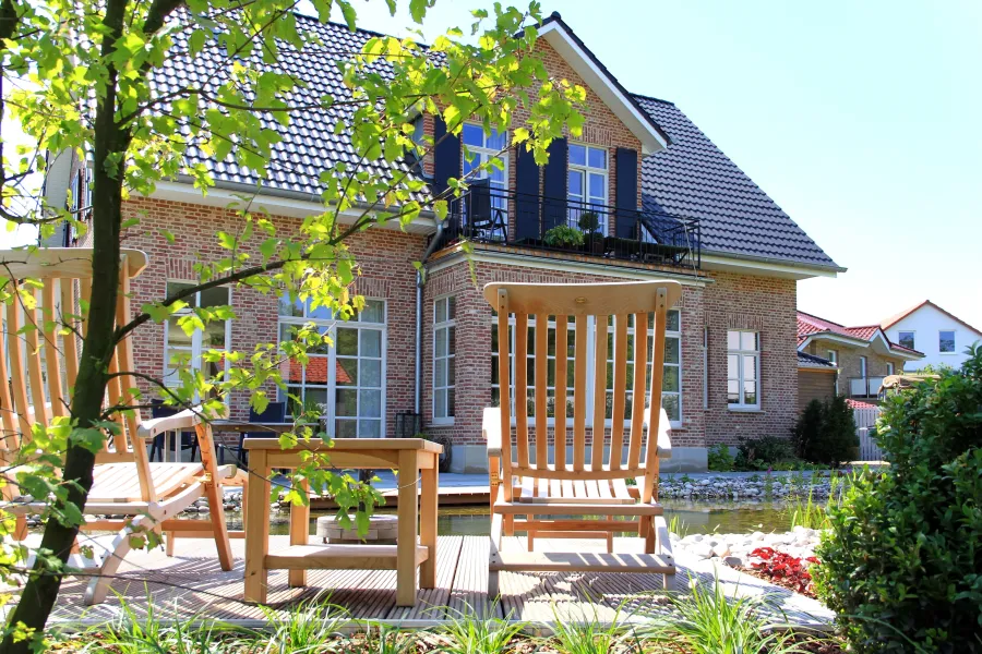 Landhausvilla in Minden: Terrasse mit Holzmöbeln vor der Landhausvilla