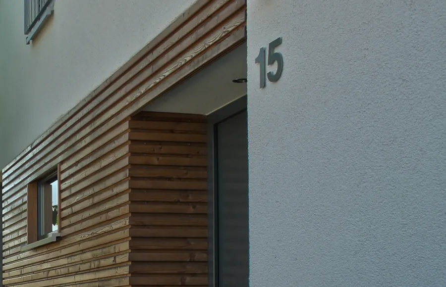 Einfamilienhaus in Löhne: Holzverkleidung mit Hausnummer, Detail