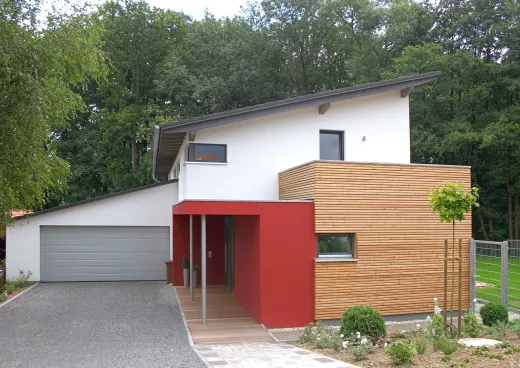 Einfamilienhaus in Löhne: Wohnhaus mit Pultdach, Holzkubus und rotem Eingang